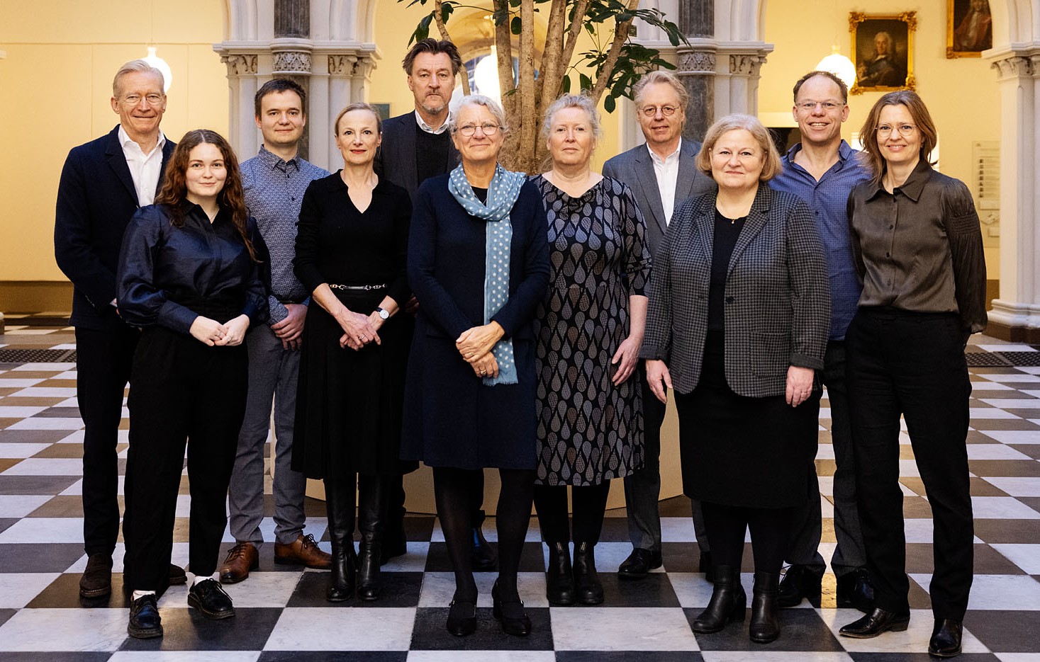 Billede af KU's bestyrelse stående foran et træ i KU's atrium i museumsbygningen